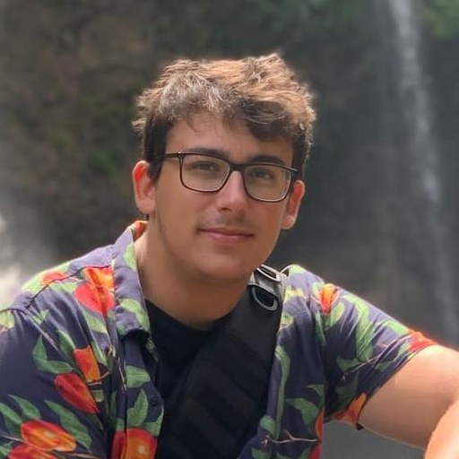 Mattia, the founder of Xposure, sitting on a rock in front of a waterfall